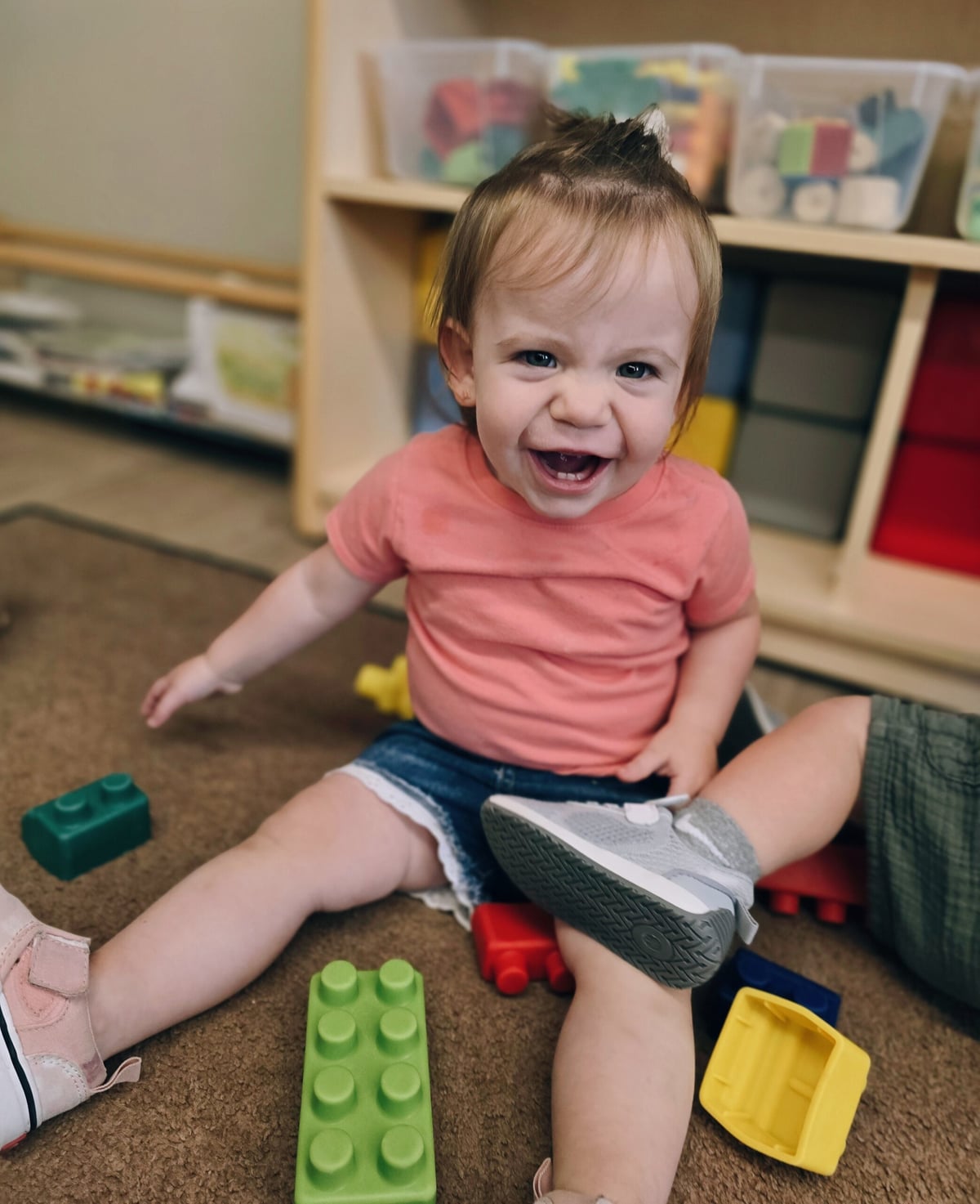 Smiling toddler child playing with blocks during center time at Primrose School at Heritage in Fort Worth, Texas.