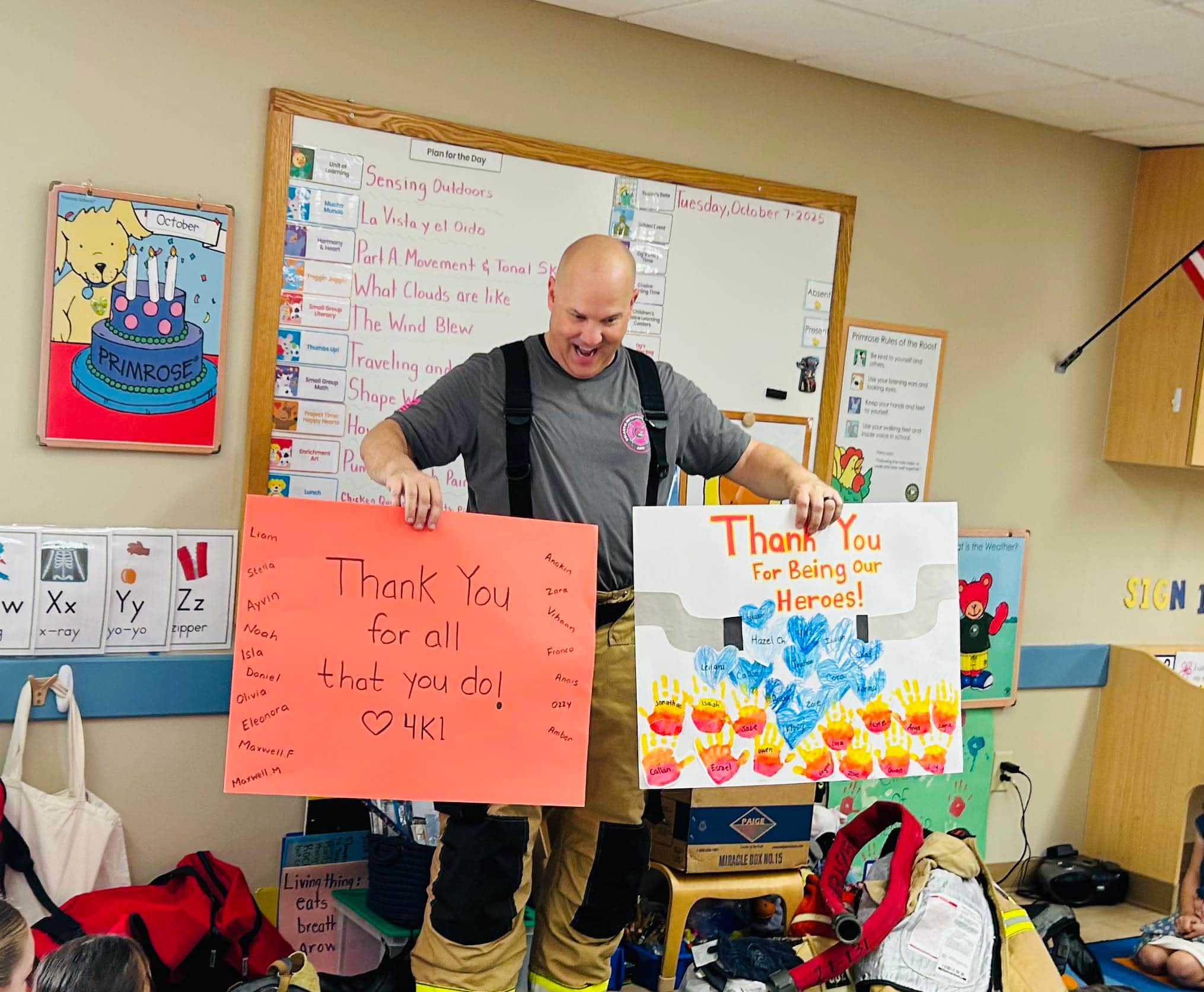 firefighter holding up two cards standing in a classroom