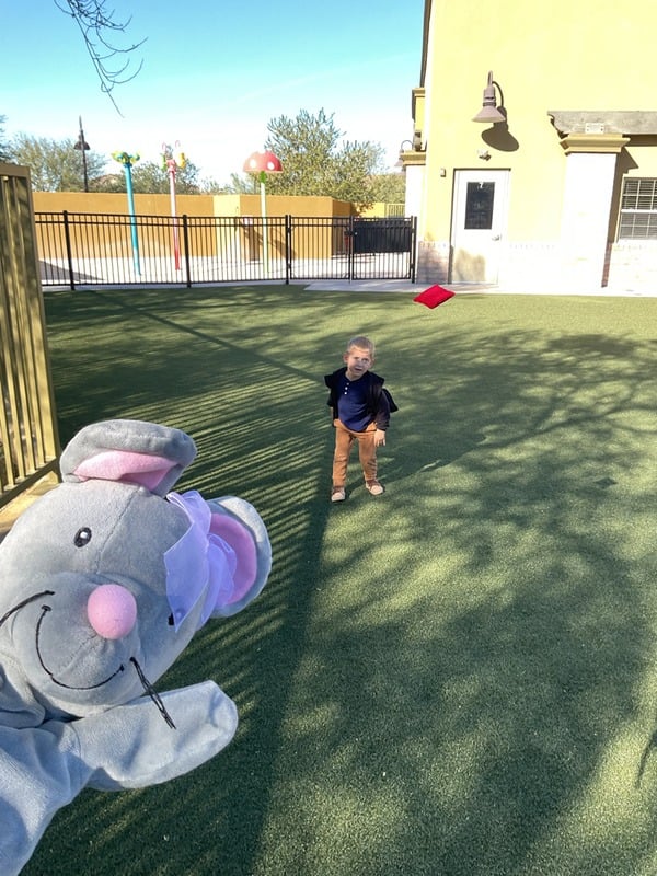 Preschool student enjoying outdoor playtime while developing gross motor skills, confidence, and coordination in a safe learning environment.