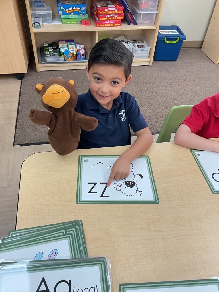 Preschool student identifying and tracing the letter Z during a hands-on literacy activity that builds letter recognition and phonics skills.
