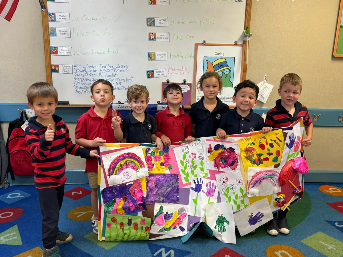 children posing and smiling with a poster of collages