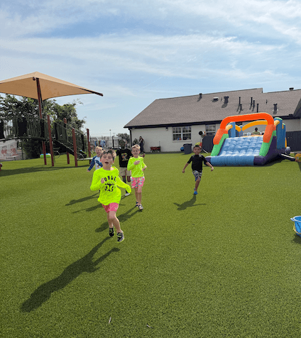 Kids running and having fun at their summer adventure club field day