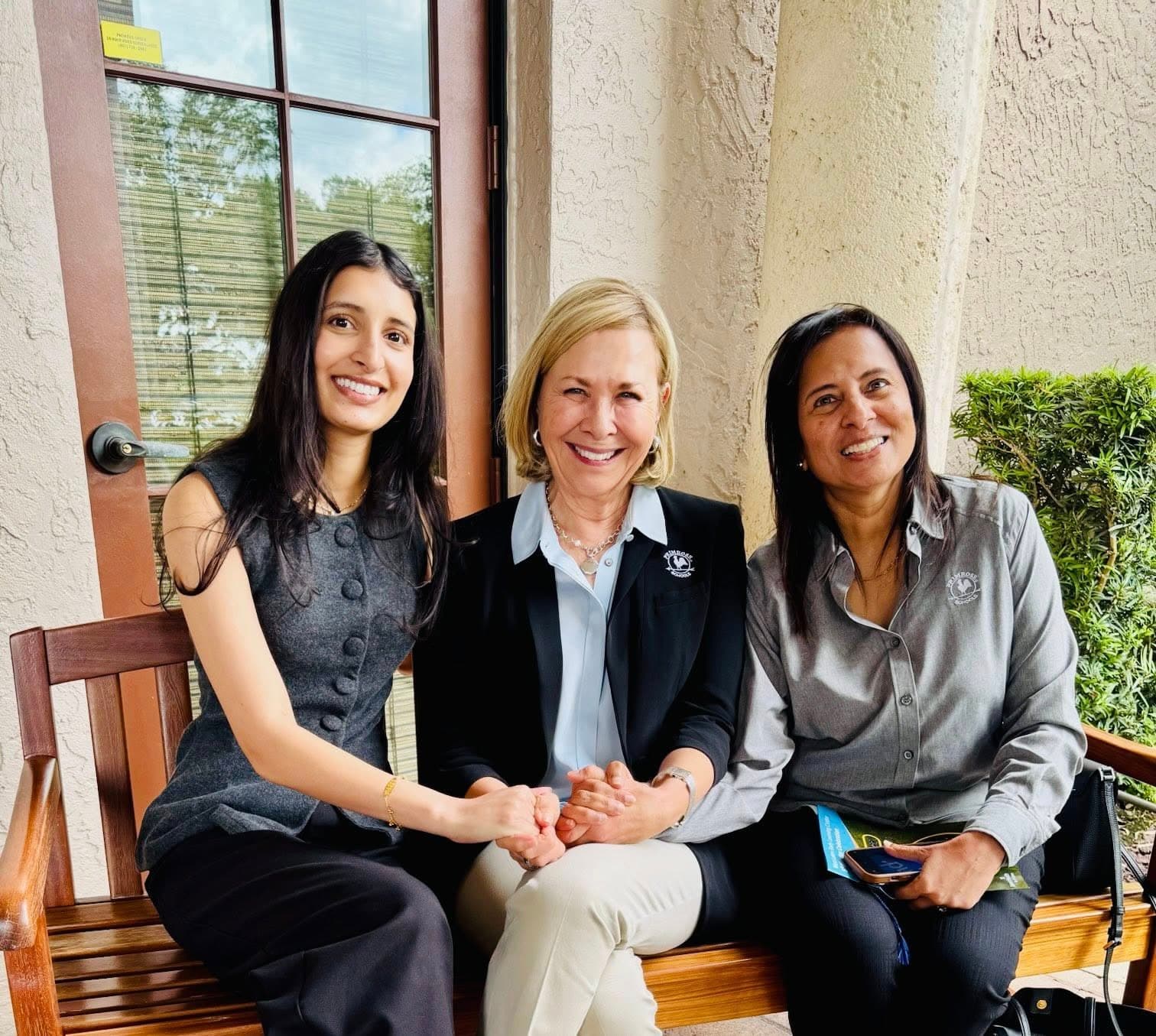 three women two with dark hair and grey shirts and one with blonde hair
