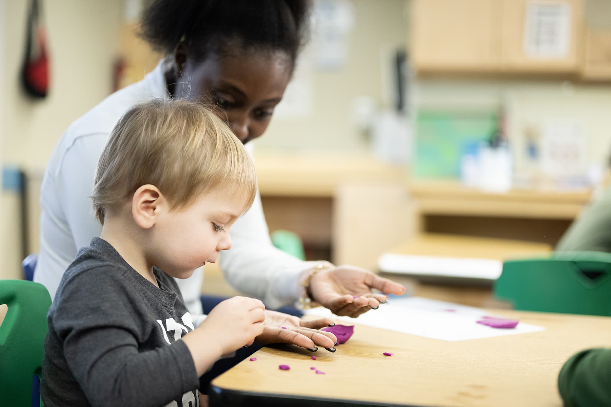 toddler and teacher doing a craft