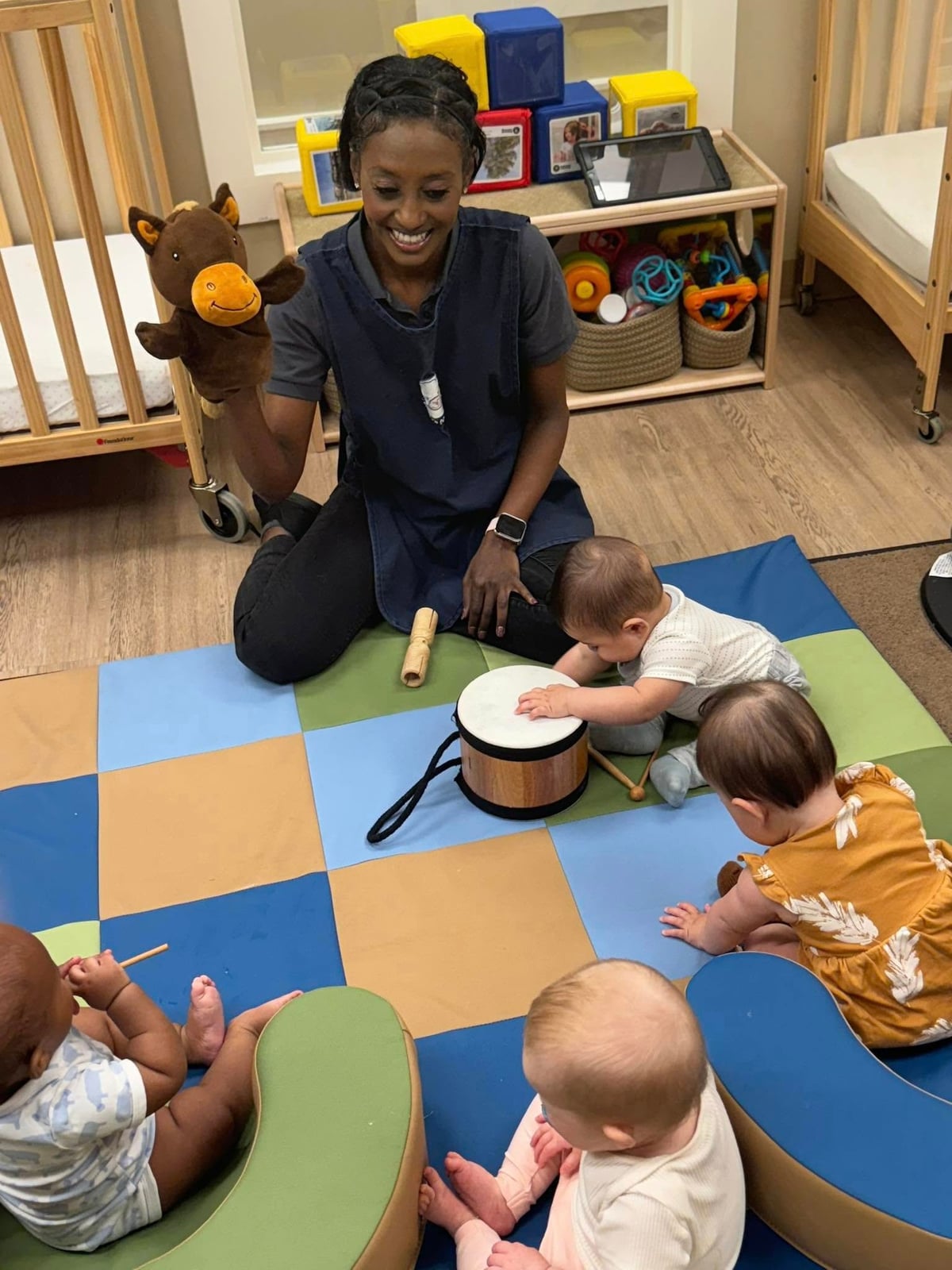 teacher using a puppet to demonstrate playing an instrument