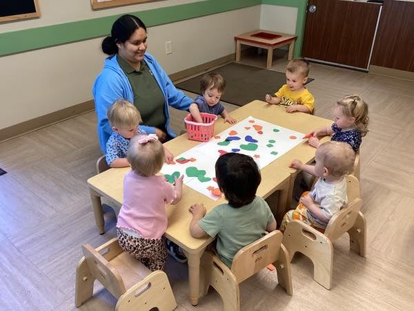 seven toddlers at a table, creating a college with their teacher