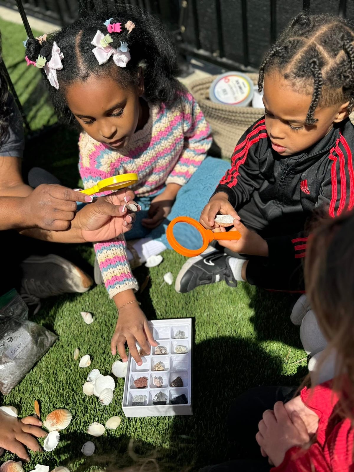 children observing rock and mineral collection on the playground