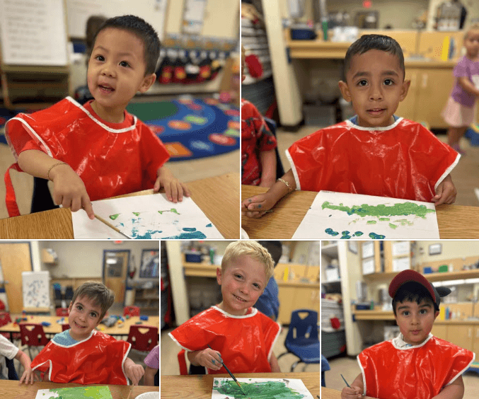 children in red smocks painting and smiling