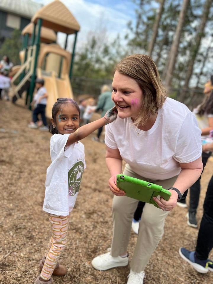 teacher standing on playground with a child