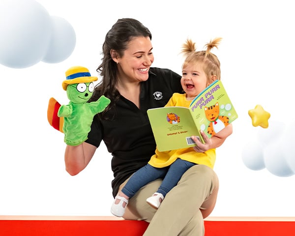 teacher holding a child while reading a book together