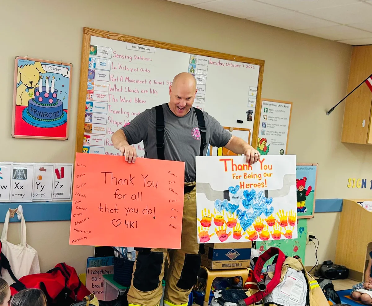 firefighter holding up two cards standing in a classroom