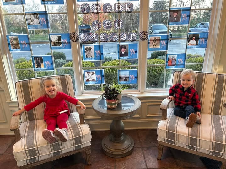 2 children sitting in chairs smiling