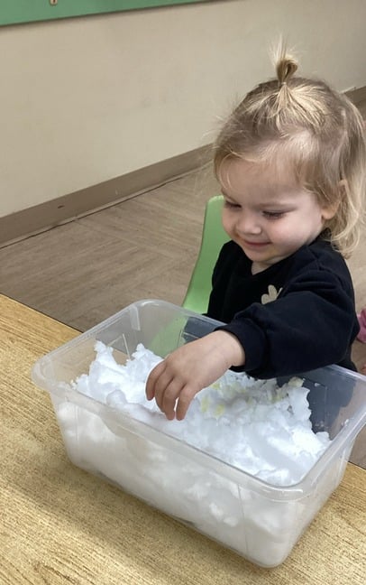 child smiling playing in the snow