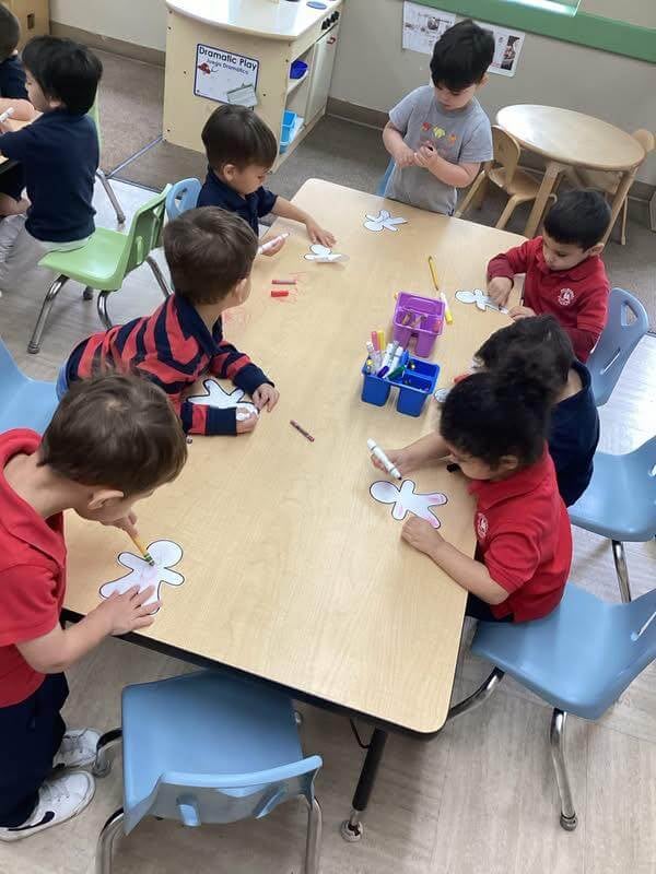 children making gingerbread men at a table with markers and