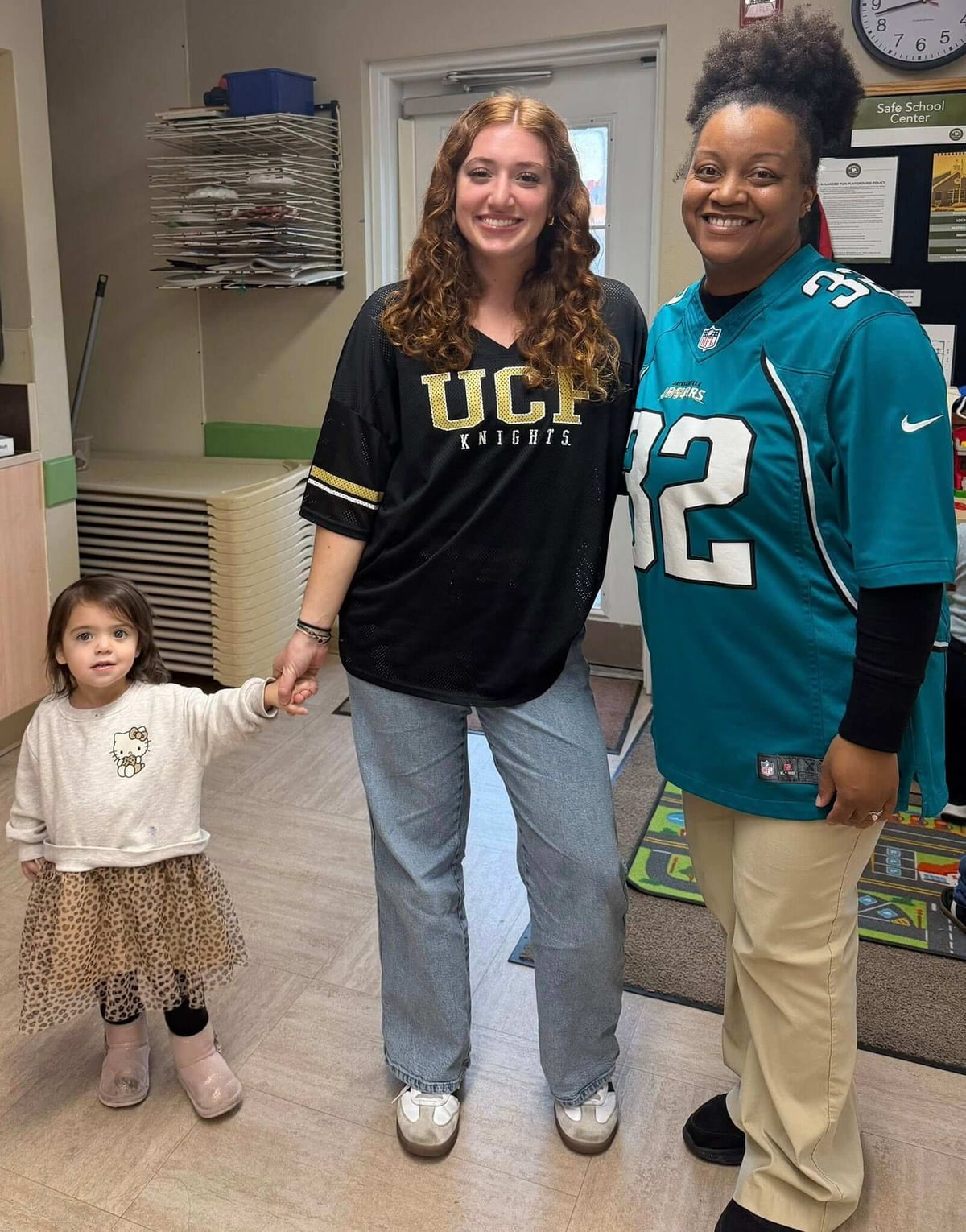 child and two adults in a classroom
