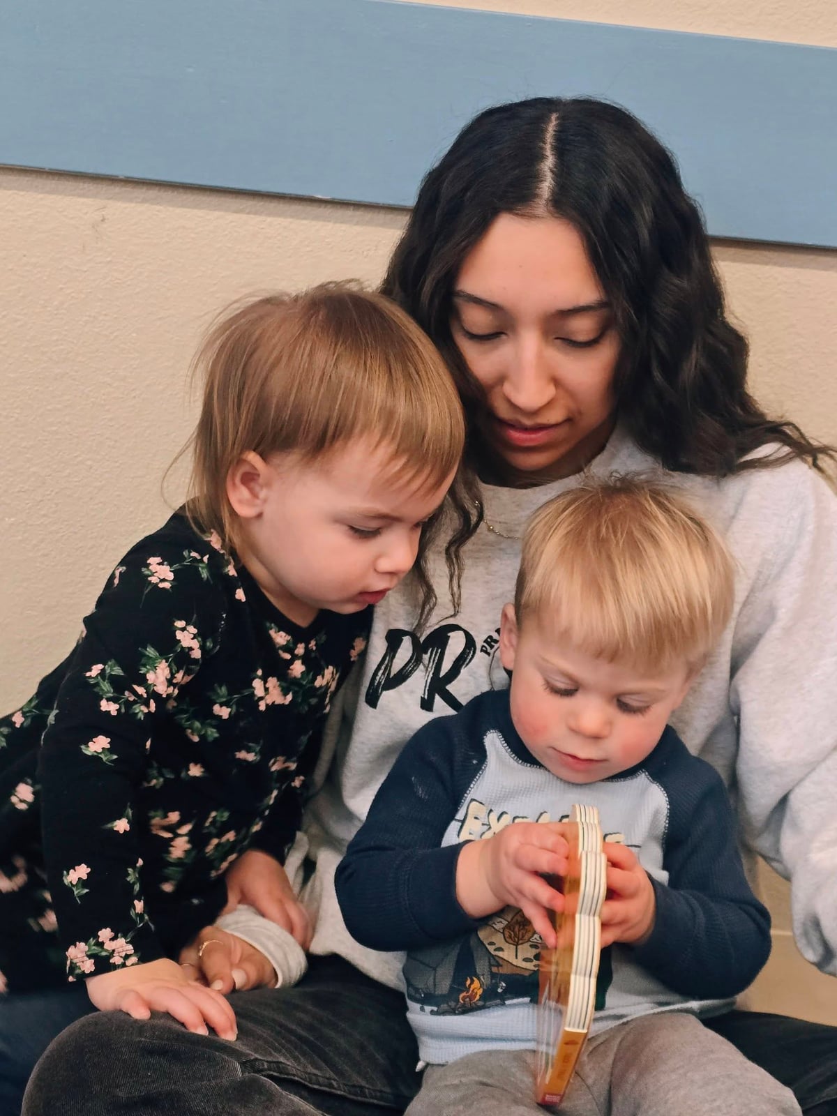 Teacher and toddlers reading a book together in a daycare classroom in Fort Worth, TX.