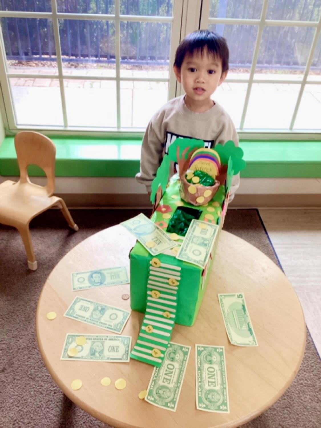 boy wearing green standing in front of a leprechaun trap