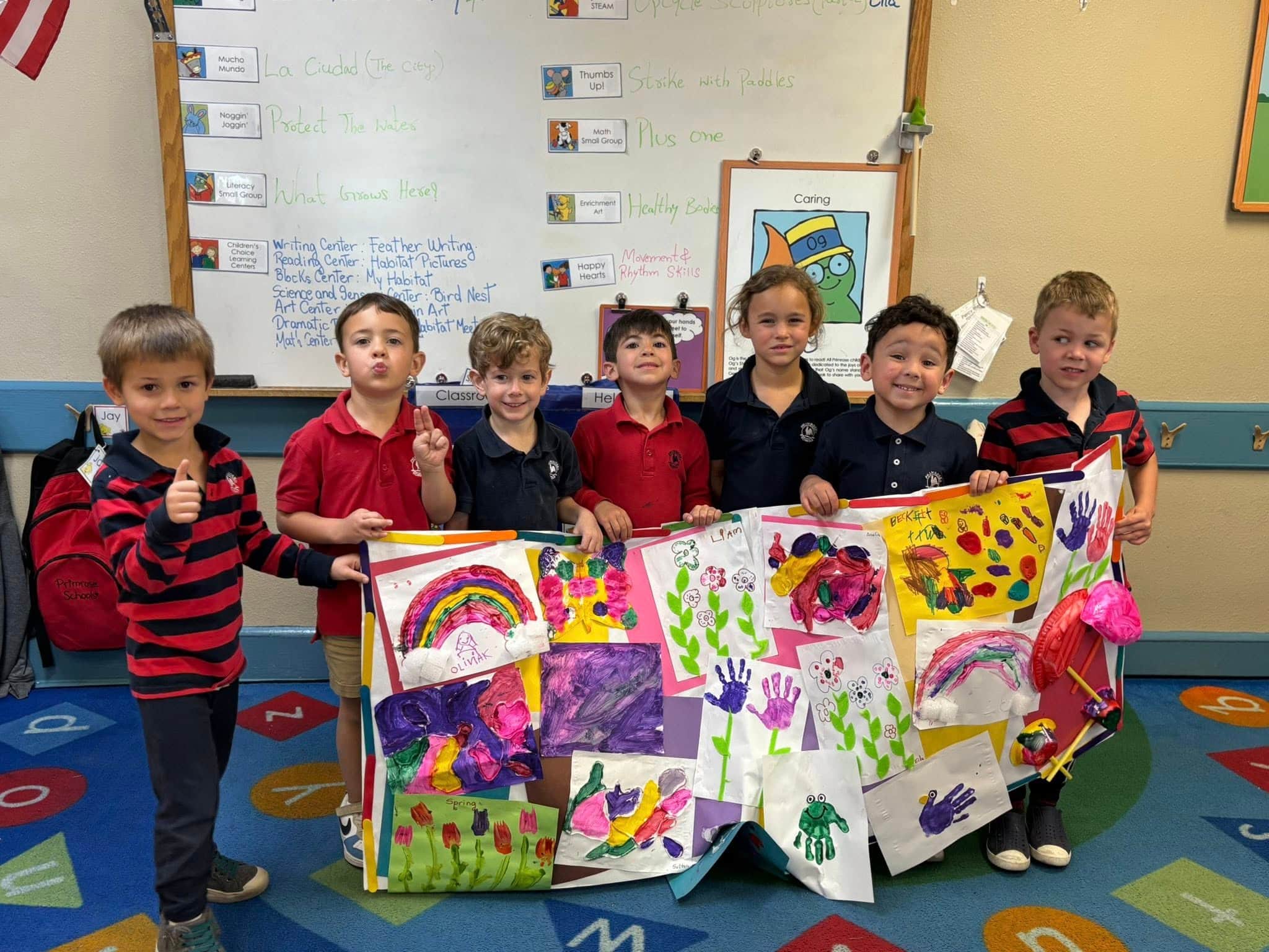 children posing and smiling with a poster of collages