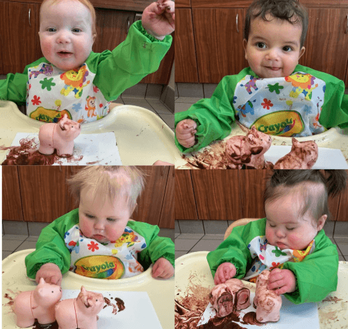 children painting pig in mud scene wearing smock having fun