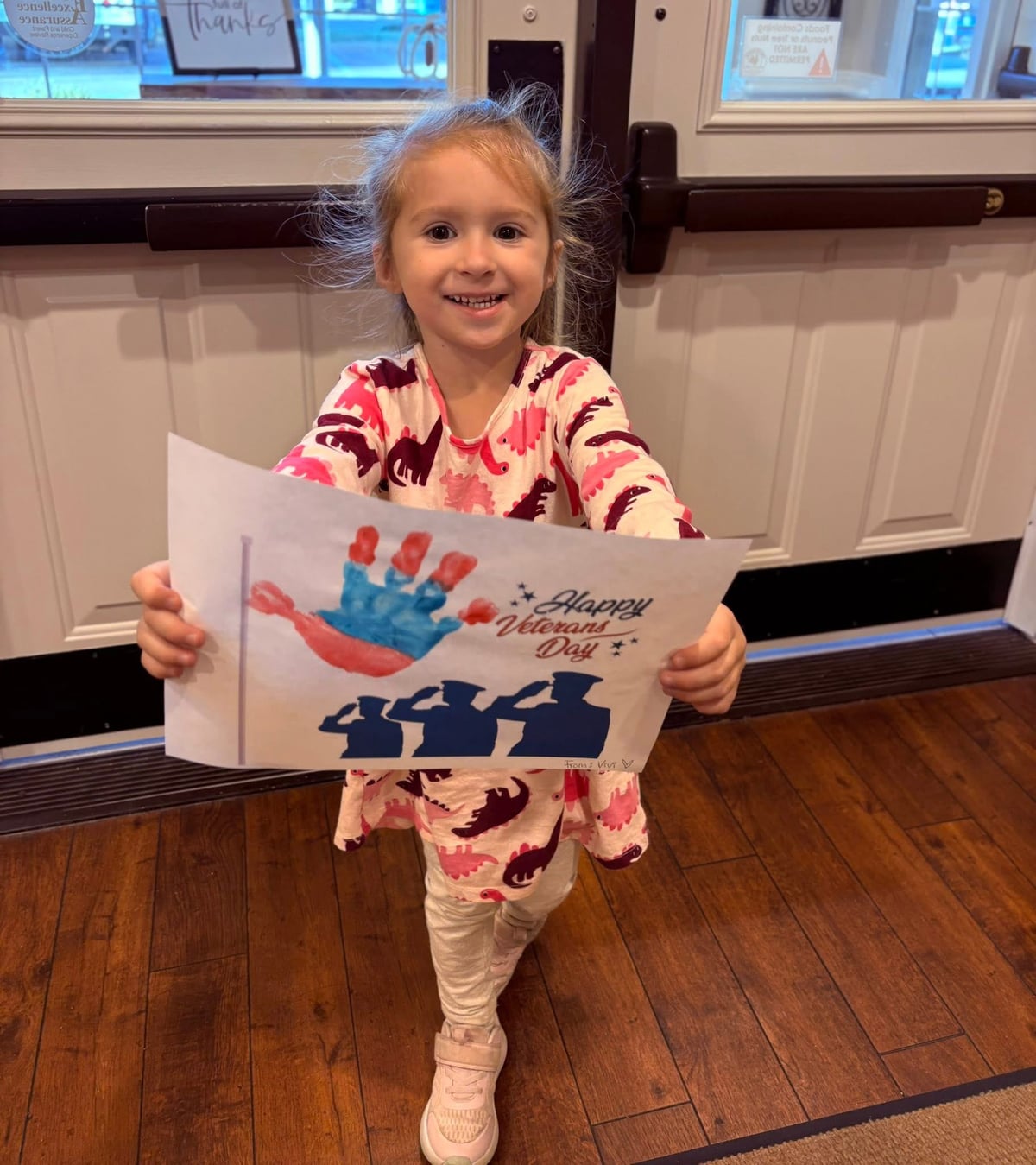 Child holding up a Veterans day craft