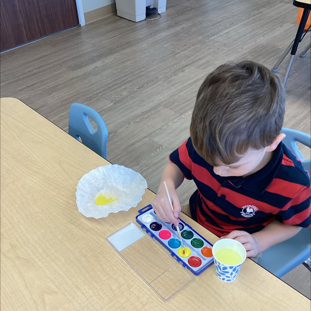 Child in stripe shirt using water color