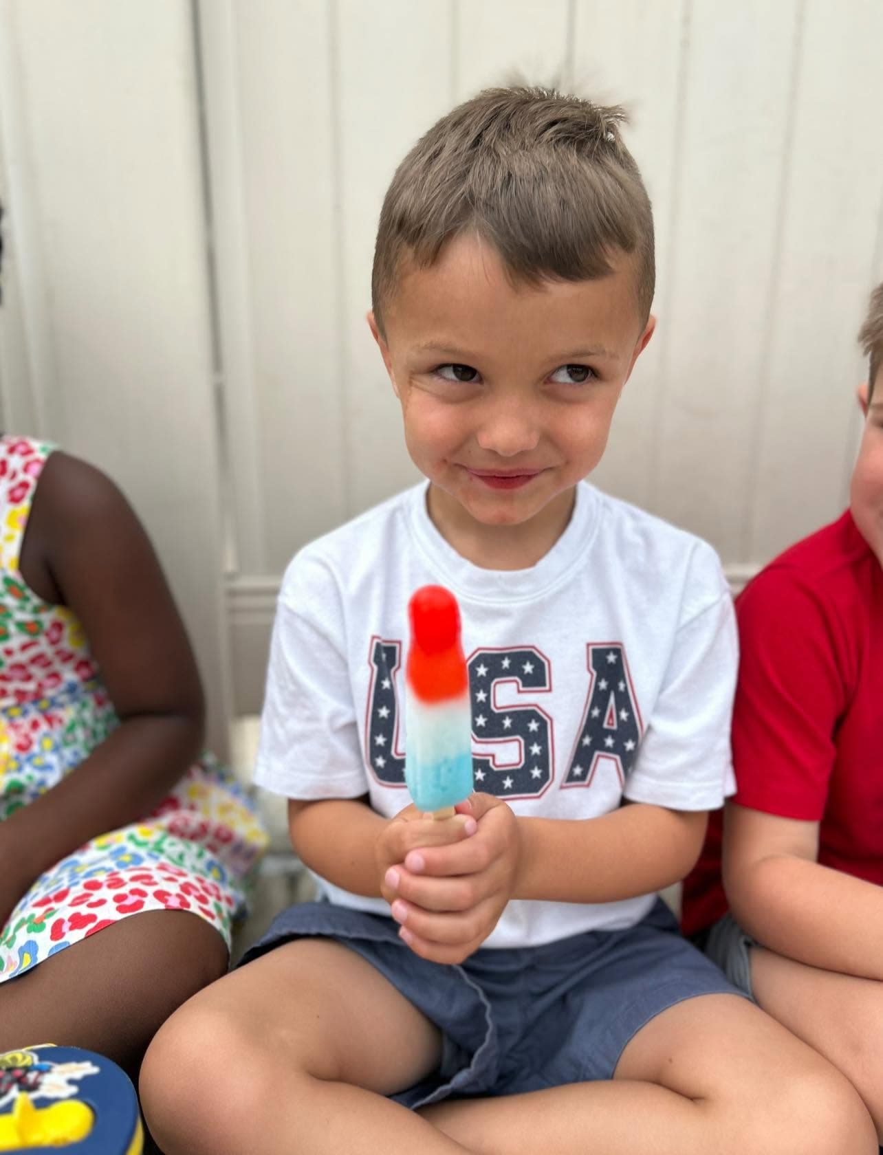 A child eating a bomb pop Popsicle