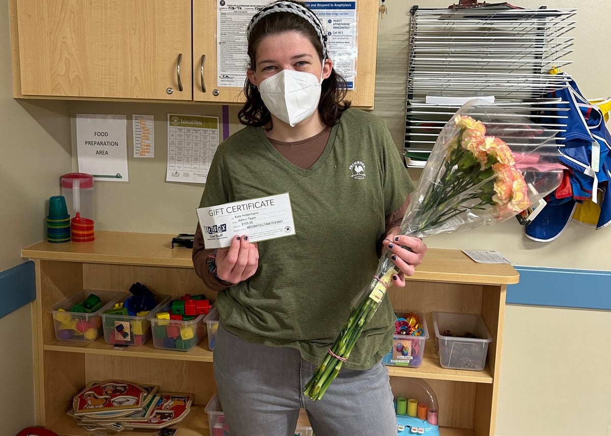 teacher holding flowers wearing a mask