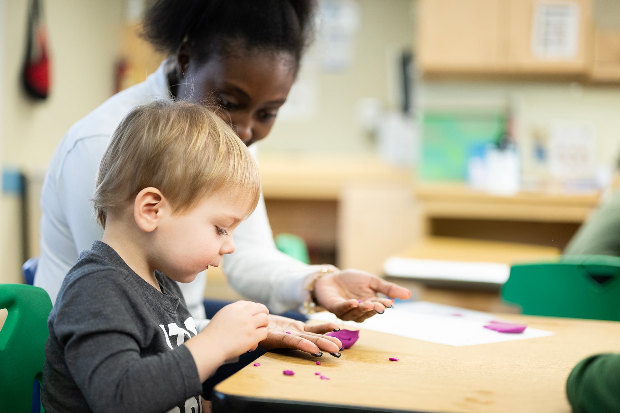 toddler and teacher doing a craft