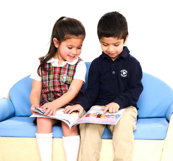 children sitting on a couch reading together